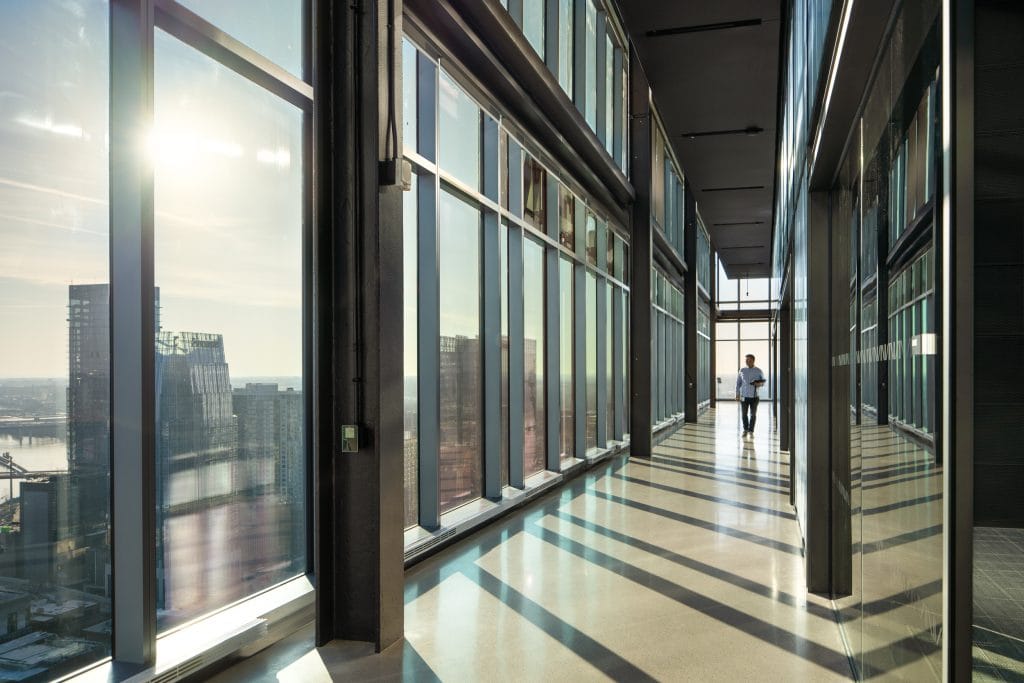Alliance Bernstein 19 Sunlit glass hallway with reflections and views of the downtown Nashville cityscape.