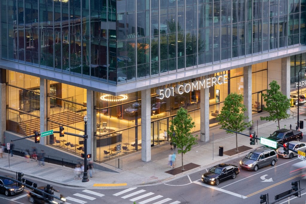 Alliance Bernstein 2 Street-level view of 501 Commerce building in downtown Nashville with floor-to-ceiling glass and modern design.