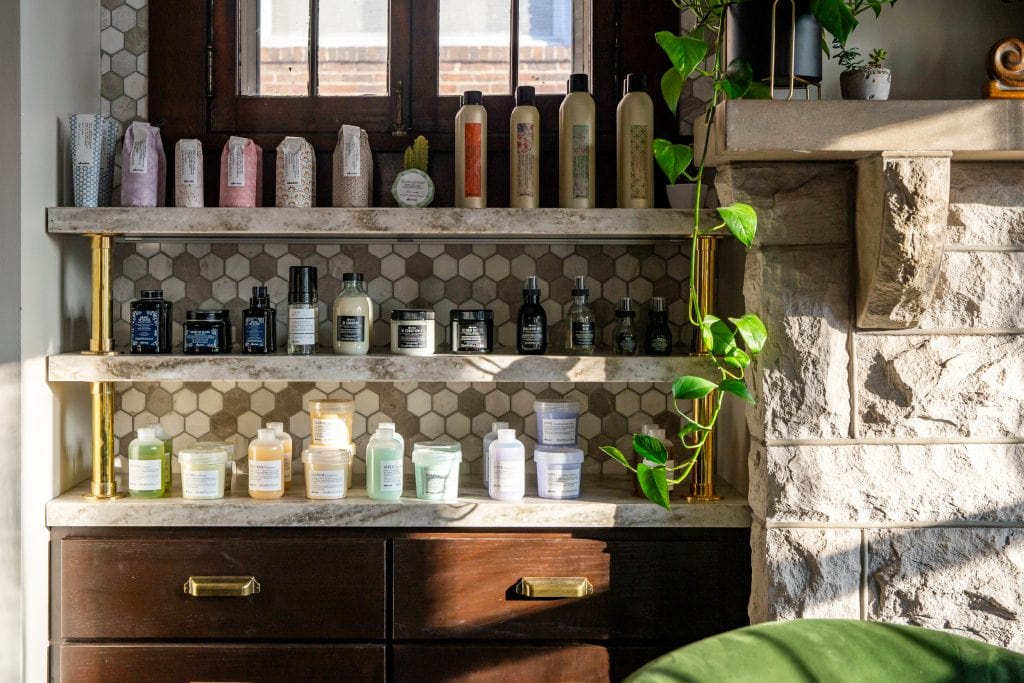 Bangarang 5 Modern shelving with hexagonal tile backsplash and curated hair care products.