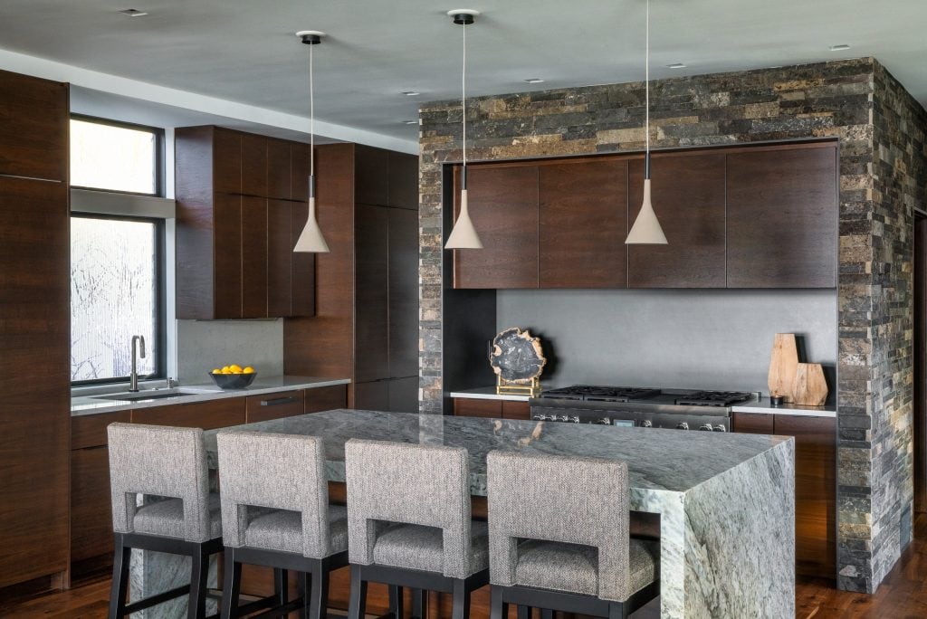 LAKESIDE CONTEMPORARY 5 Kitchen island and dining area with stone and wood accents in a modern home.
