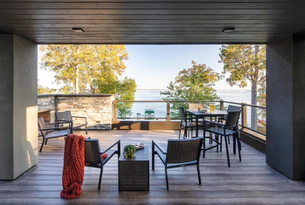 LAKESIDE CONTEMPORARY 1 Lakefront balcony with outdoor seating and glass railings overlooking Lake Bemidji.