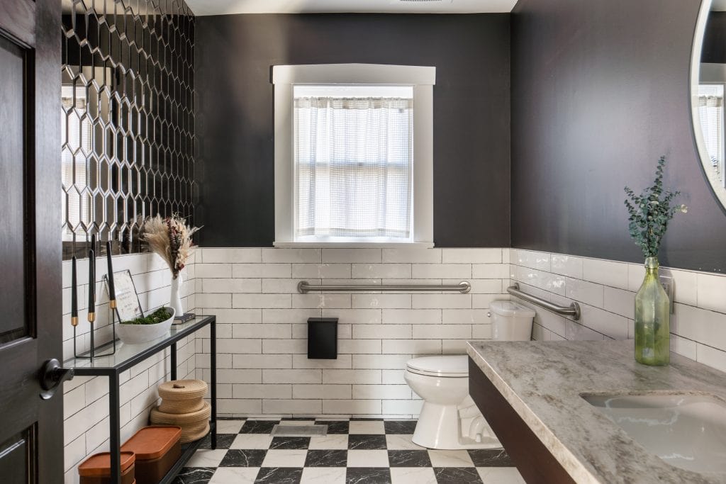 Bangarang 7 Modern bathroom with black walls, white subway tiles, and decorative accents.