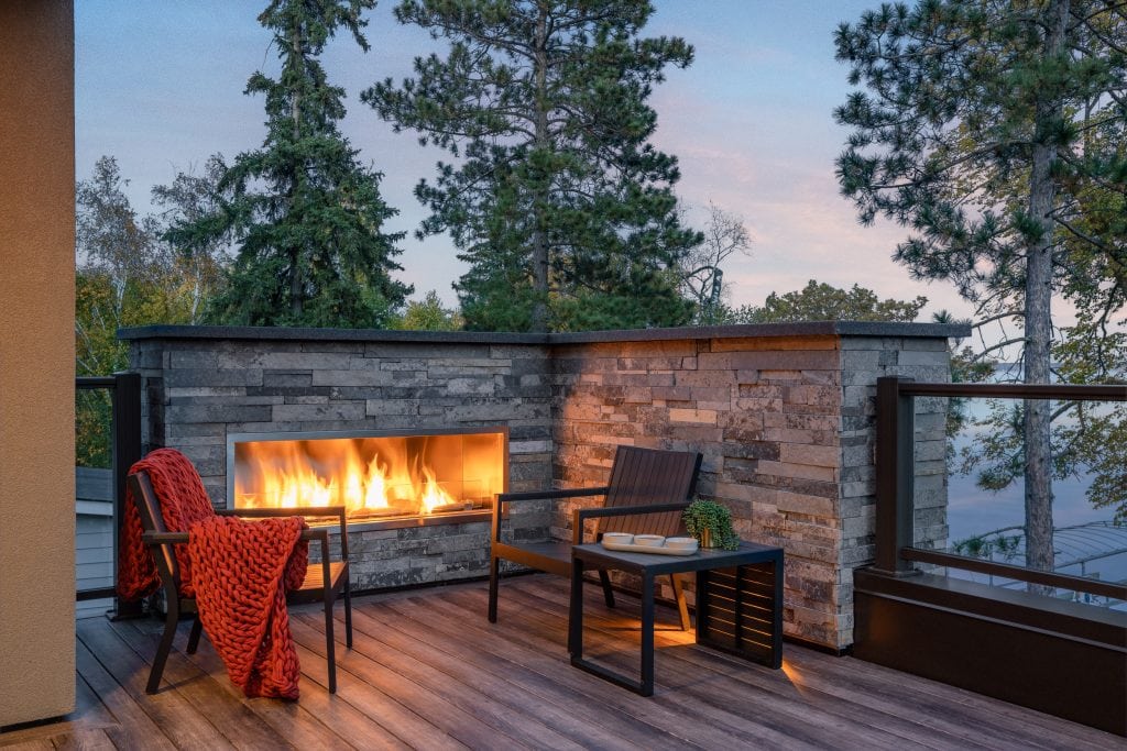LAKESIDE CONTEMPORARY 12 Rooftop patio with a built-in fireplace and seating area overlooking the trees.