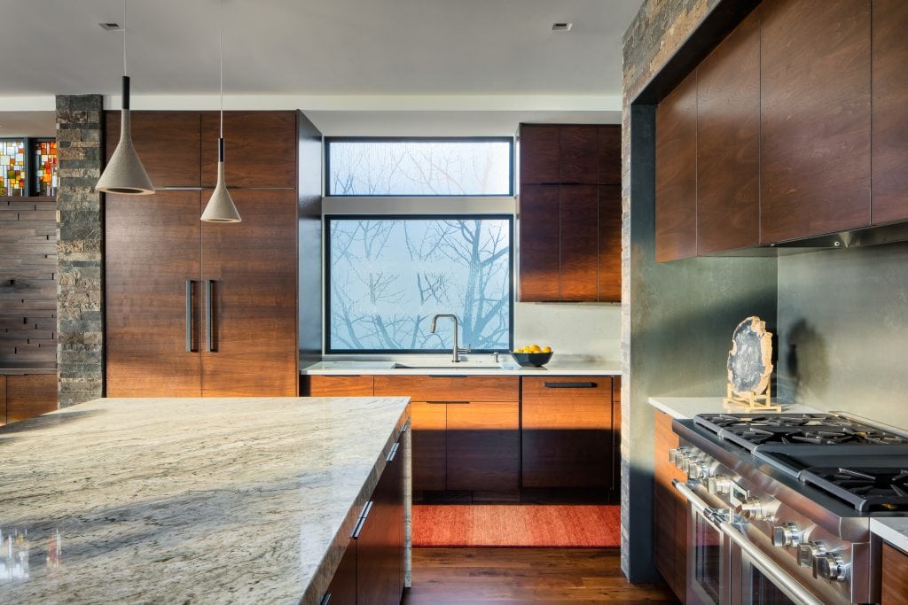 LAKESIDE CONTEMPORARY 4 Modern kitchen with wood cabinetry, pendant lights, and frosted glass windows.
