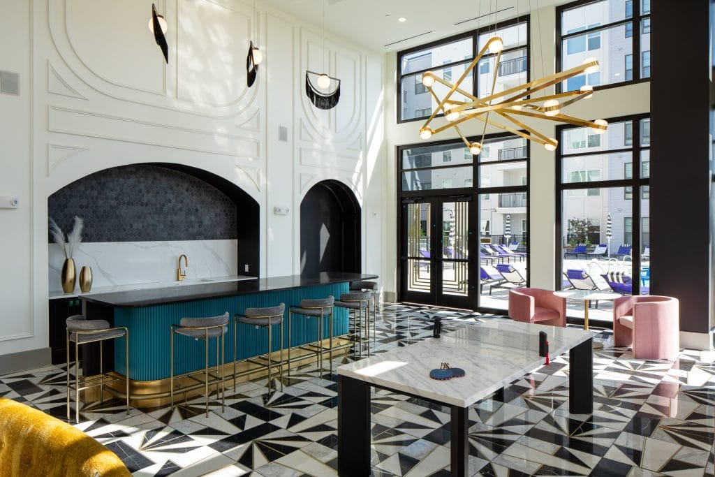 THE BOULEVARD 8 Common area with a bar, game tables, and a lounge featuring modern furnishings and natural light.