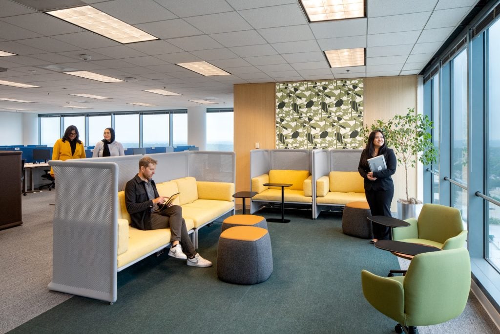 Capgemini Atlanta 8 Modern office seating area with bright yellow couches and city view.