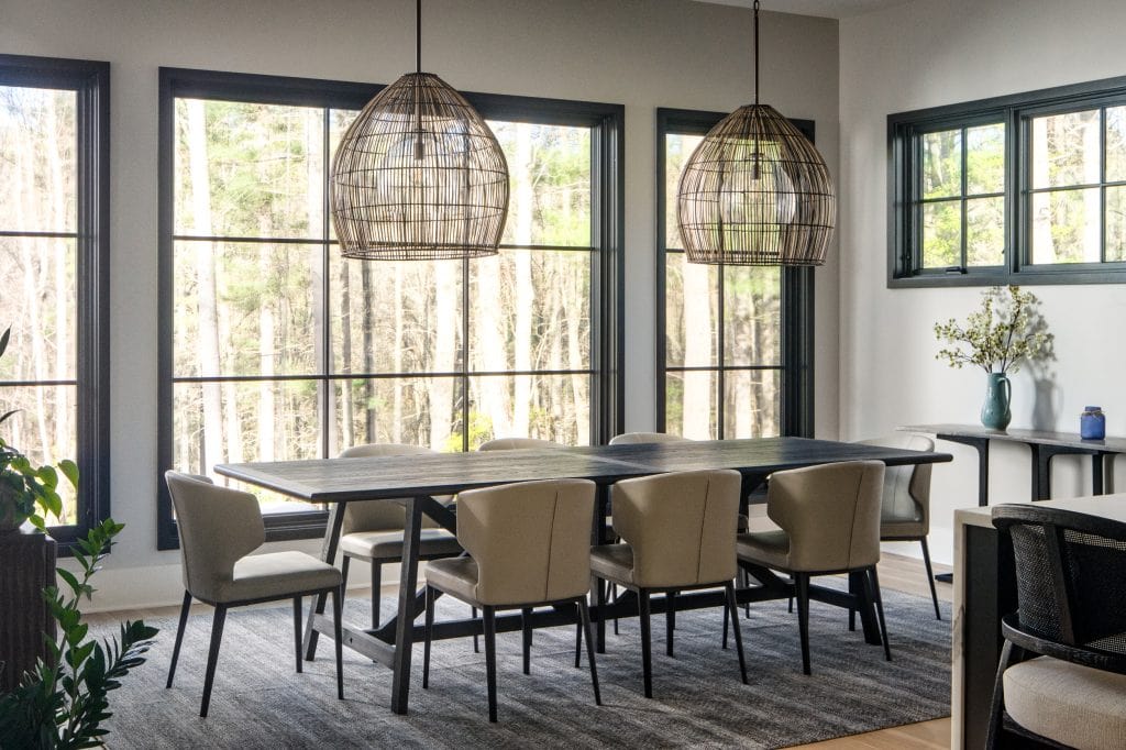 Flowering Vine 5 Dining room with wicker pendant lights and large black-framed windows.