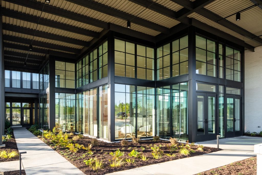 Brio 3 Industrial-modern entrance with black steel beams and landscaped pathways.
