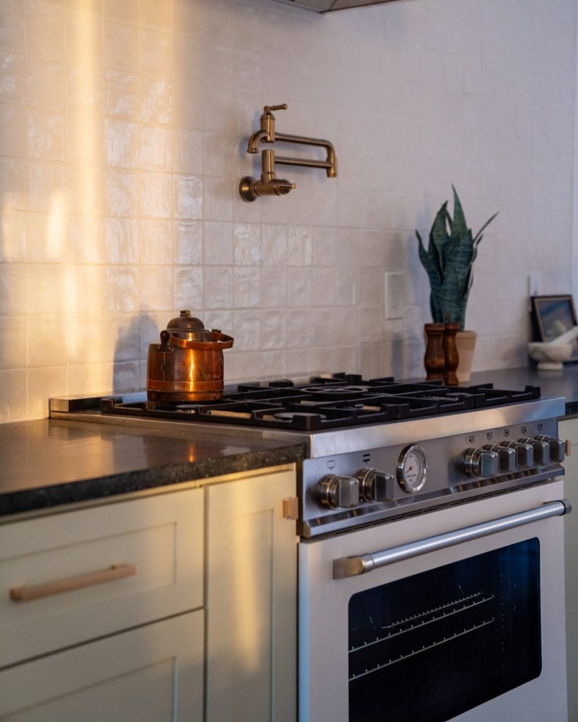 Eastside 7 Kitchen stove with sunlit tile backsplash.