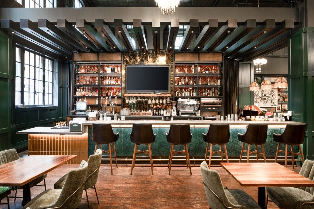 Countrypolitan Hotel Nashville 2 Elegant bar interior featuring chandeliers, wood accents, and green paneling.