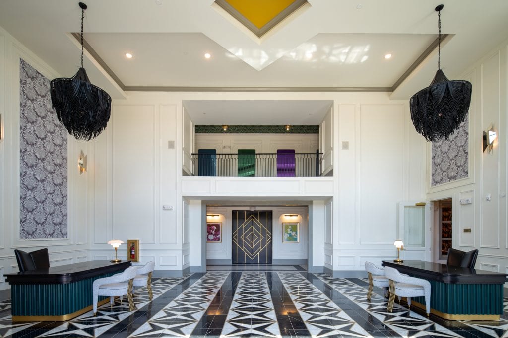 THE BOULEVARD 3 Luxury lobby with geometric flooring, black chandeliers, and bold gold accents.