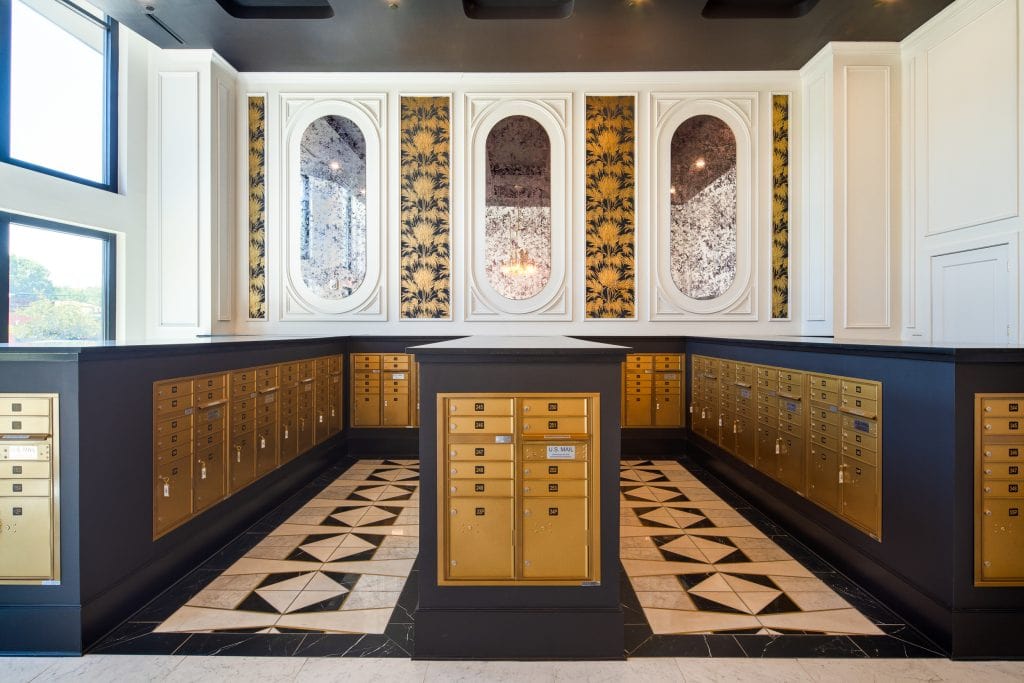 THE BOULEVARD 7 Mailroom with gold mailboxes, mirrored panels, and geometric tile flooring.