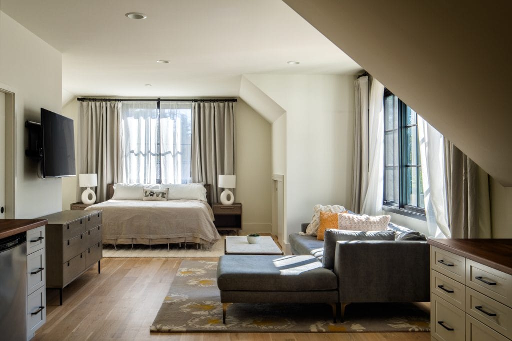 Flowering Vine 8 Master bedroom with a cozy seating area and large black-framed windows.