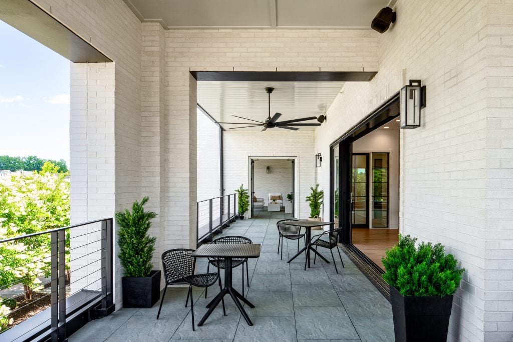 Brio 10 Modern covered patio with seating and a sleek black ceiling fan.