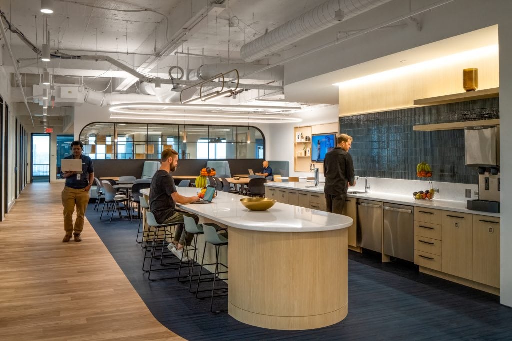 Capgemini Atlanta 5 Open break room with large communal table and modern kitchen.