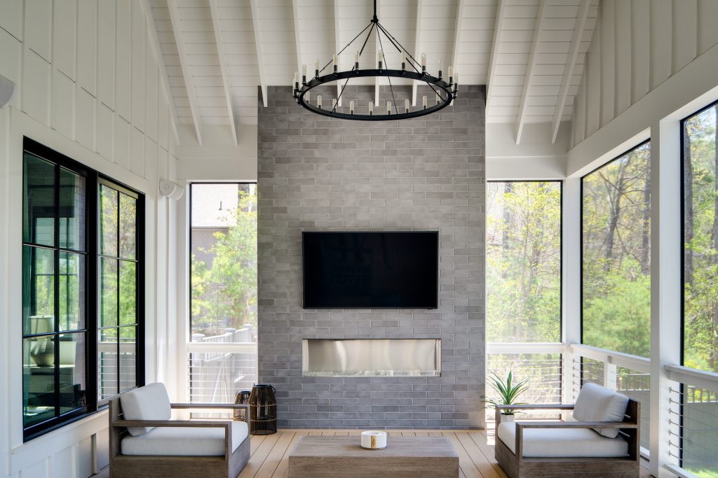 Flowering Vine 12 Screened porch with a fireplace, chandelier, and outdoor seating.