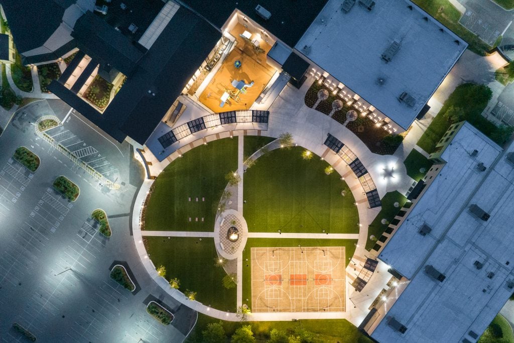 Long Hollow 1 Aerial nighttime view of a modern campus with illuminated walkways and basketball court.
