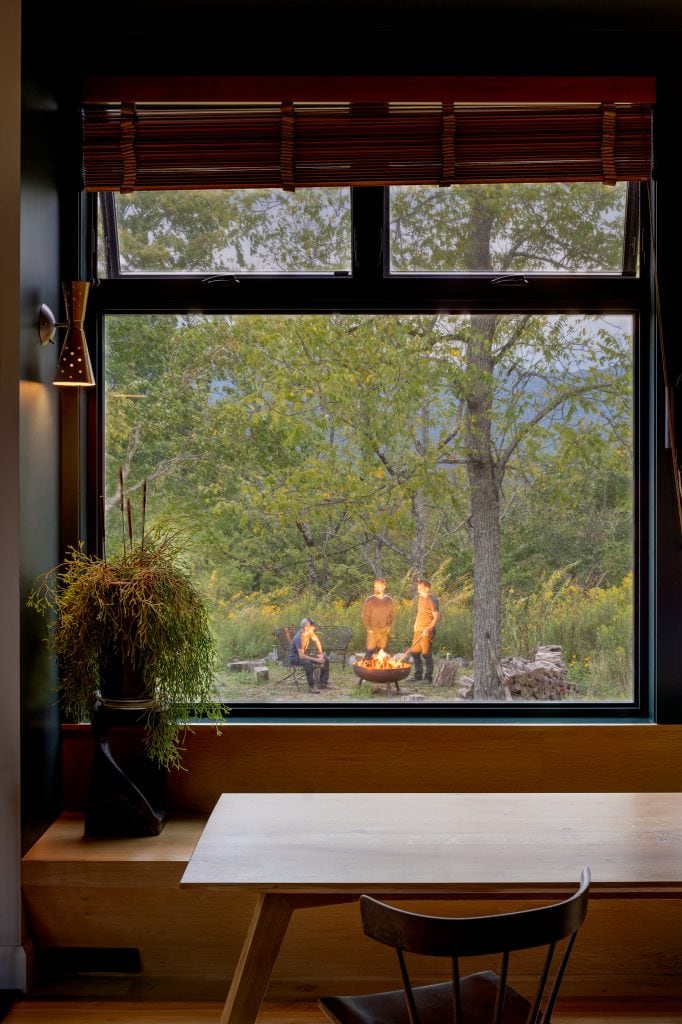 Freedom Cove 13 Dining room window with a view of an outdoor fire pit gathering.