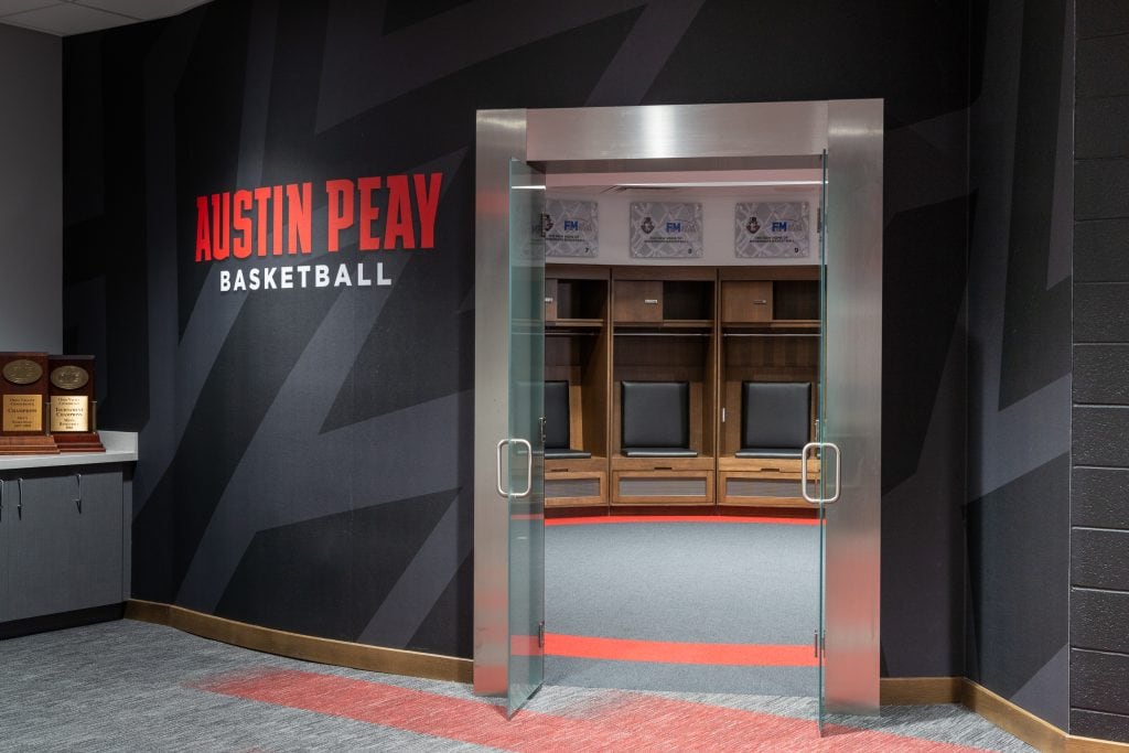FM Bank Arena 8 Modern locker room entrance featuring sleek glass doors and branding.