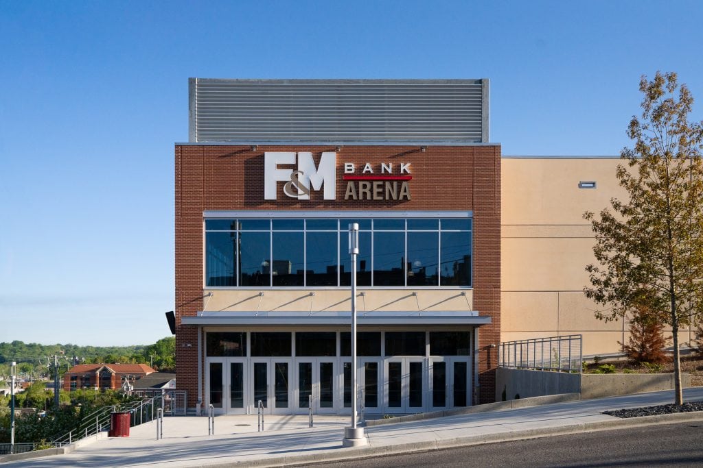 FM Bank Arena 1 Front facade of a modern arena featuring large glass windows and brick elements.