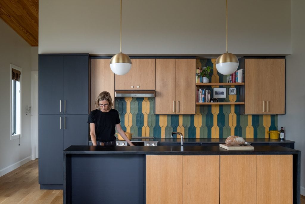 Freedom Cove 6 Contemporary kitchen with dark cabinetry and colorful tile backsplash.