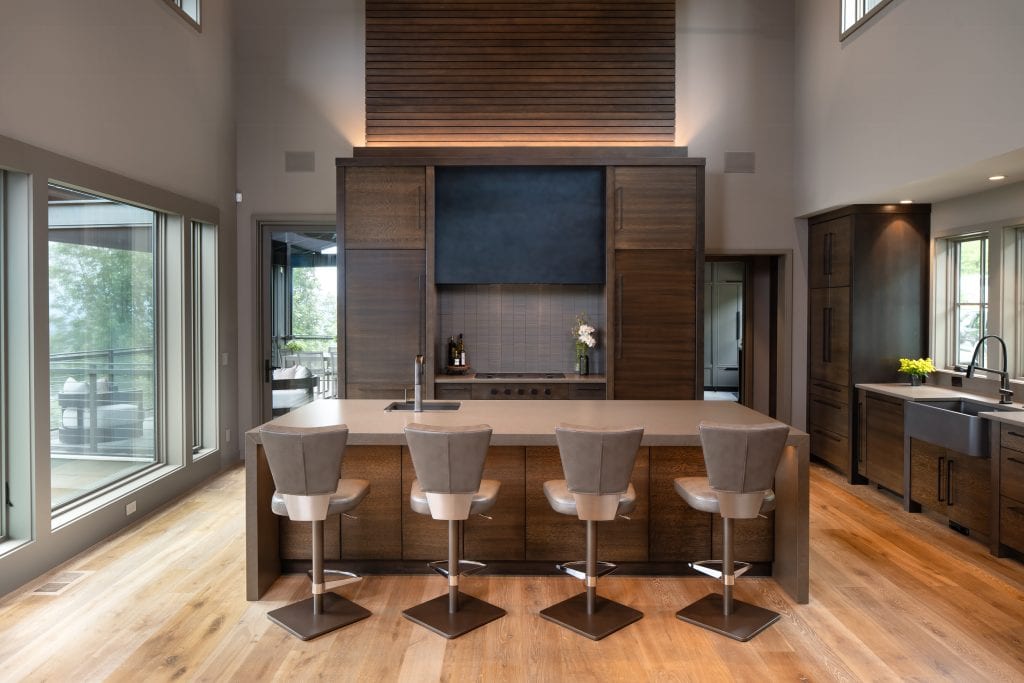 Laketown 6 Modern kitchen with dark wood cabinetry, large island, and pendant lighting.