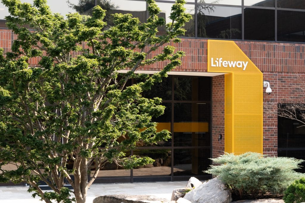 Lifeway 1 Office entrance featuring brick architecture, large windows, and a yellow feature panel.