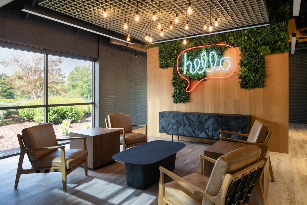 Lifeway 5 Stylish waiting area with leather chairs, greenery, and a neon "hello" sign.