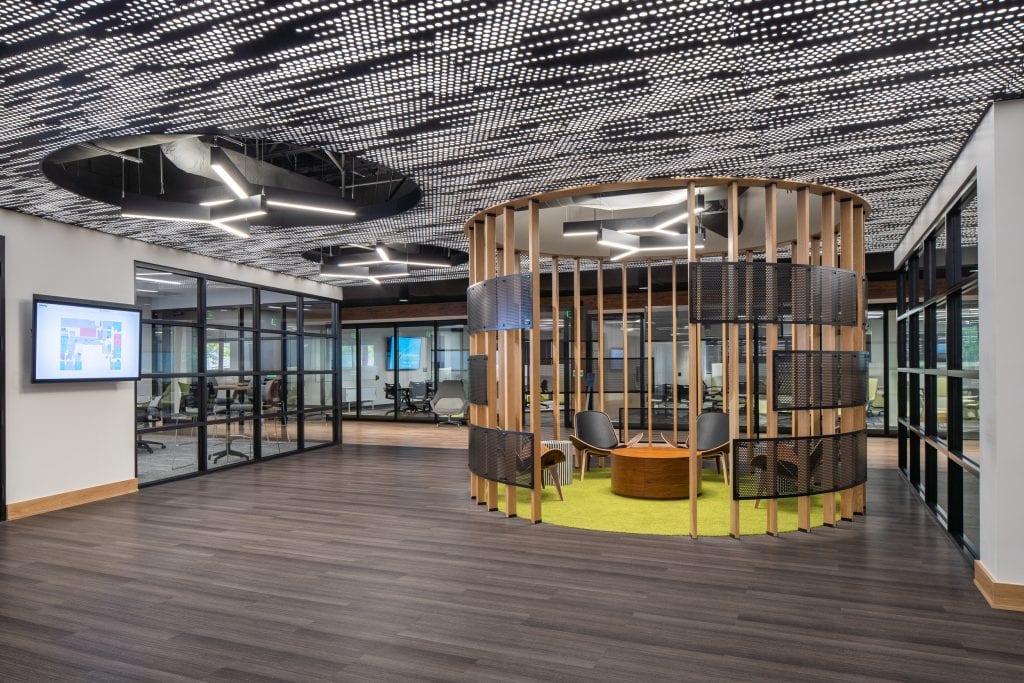 Lifeway 14 Open workspace with a circular wooden meeting pod and perforated ceiling panels.