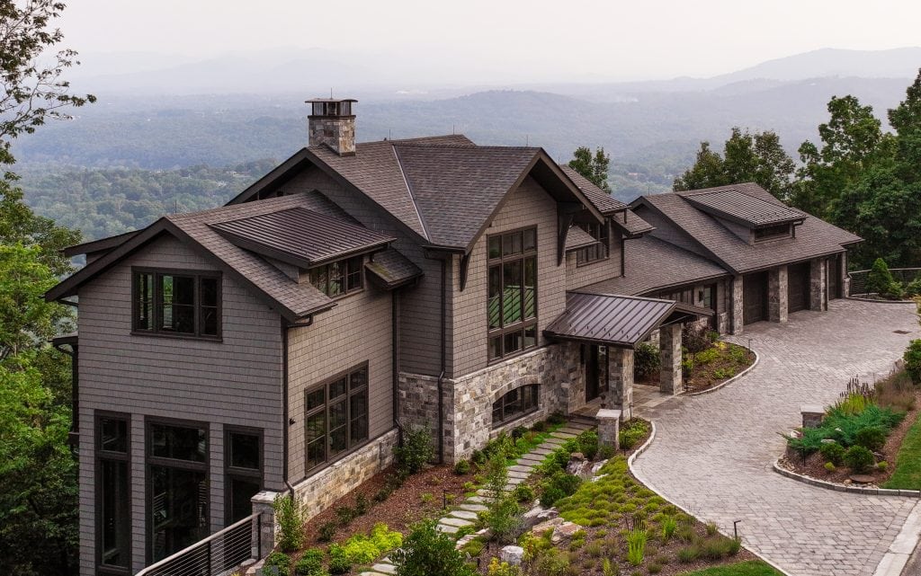 Laketown 3 Mountain home with stone and wood exterior, large windows, and scenic views.