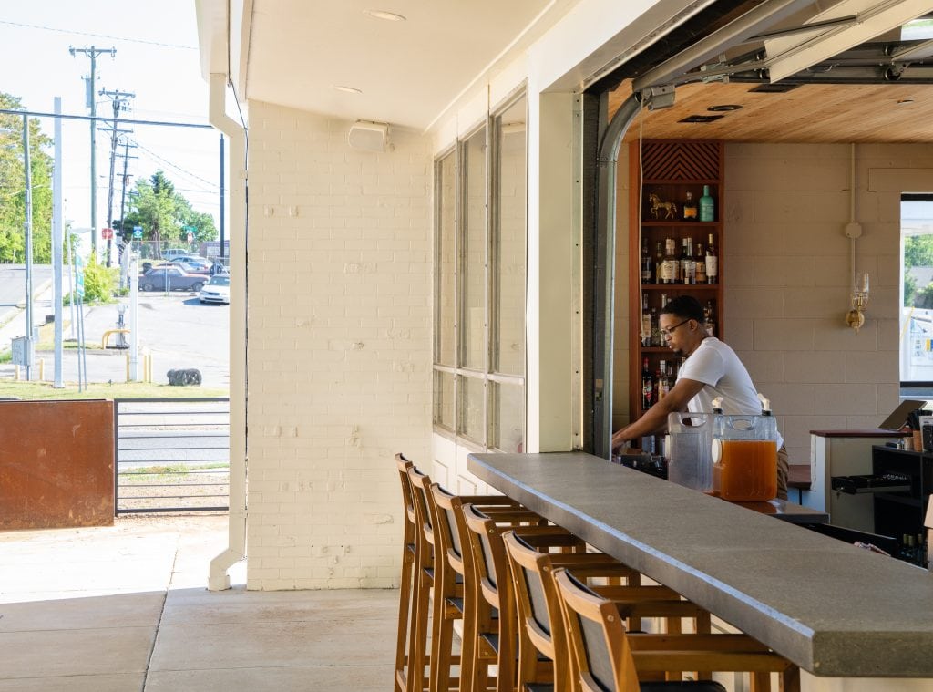 Golden Pony 16 Bartender working behind an open-air bar with a retractable garage-style window.