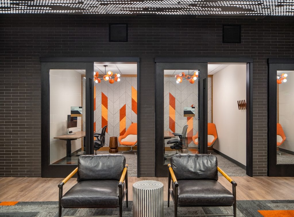 Lifeway 6 Private meeting rooms with glass walls, orange-accented lighting, and geometric wall panels.