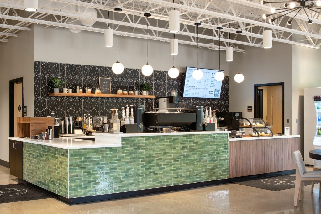 Long Hollow 8 Coffee bar with green tiled counter, black geometric backsplash, and modern pendant lighting.