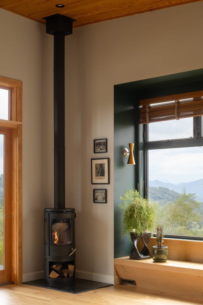 Freedom Cove 8 Modern wood-burning stove in a living space with a scenic view.