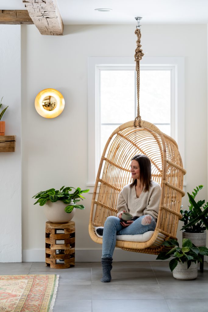 MINOR PARK MODERN 7 A cozy living space with a rattan hanging chair, natural light, and plants.
