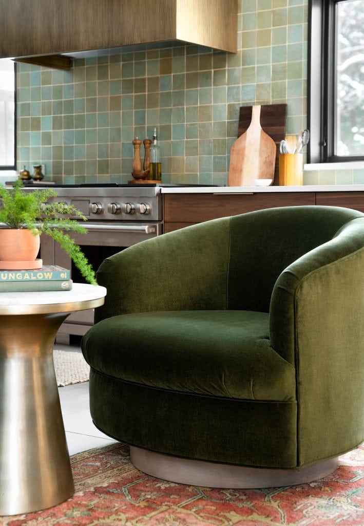 MINOR PARK MODERN 4 A cozy reading nook with a green chair and brass side table in a kitchen corner.