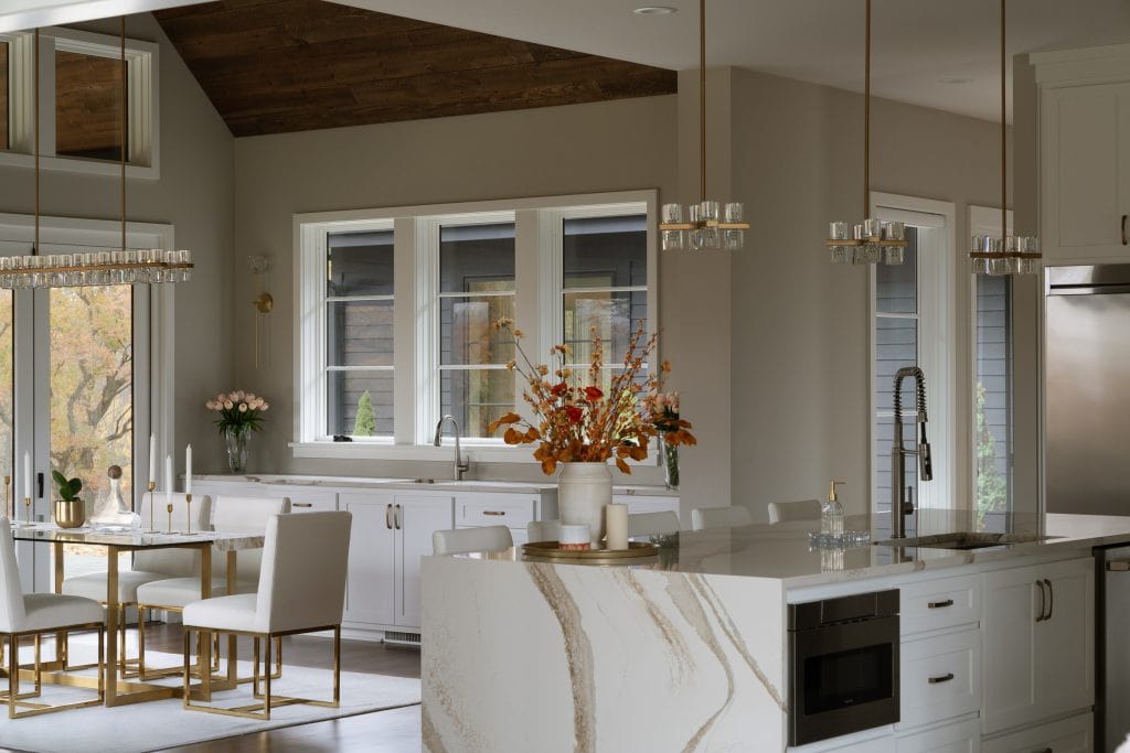 Marie 11 Modern kitchen with white cabinetry, a waterfall island, and gold accents.