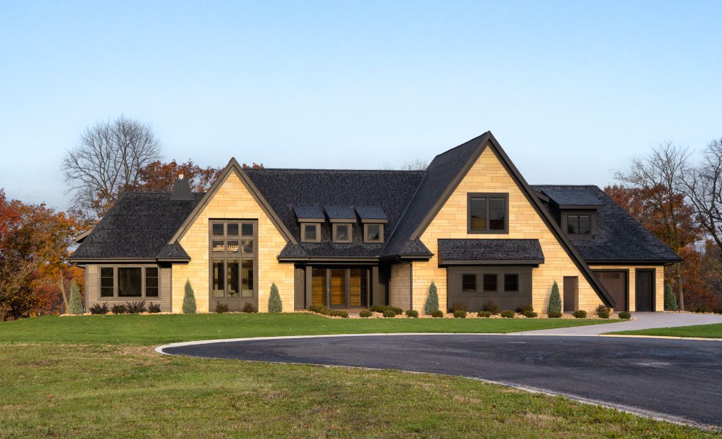 Marie 1 Modern home exterior with natural stone facade, black trim, and landscaped front yard.