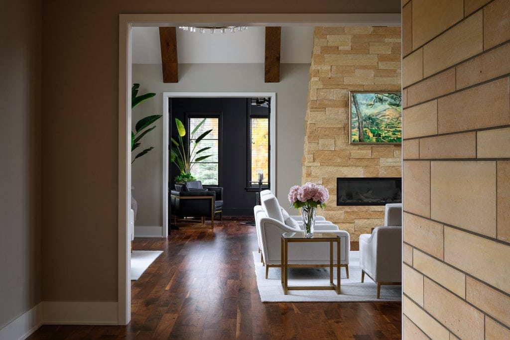 Marie 4 Open-concept living room featuring a stone fireplace, wooden beams, and elegant furnishings.