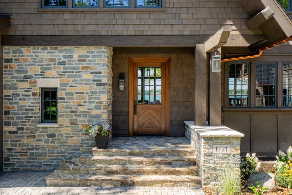LAKE POLASKI 3 Stone entryway with wooden door and stairs leading to front porch.
