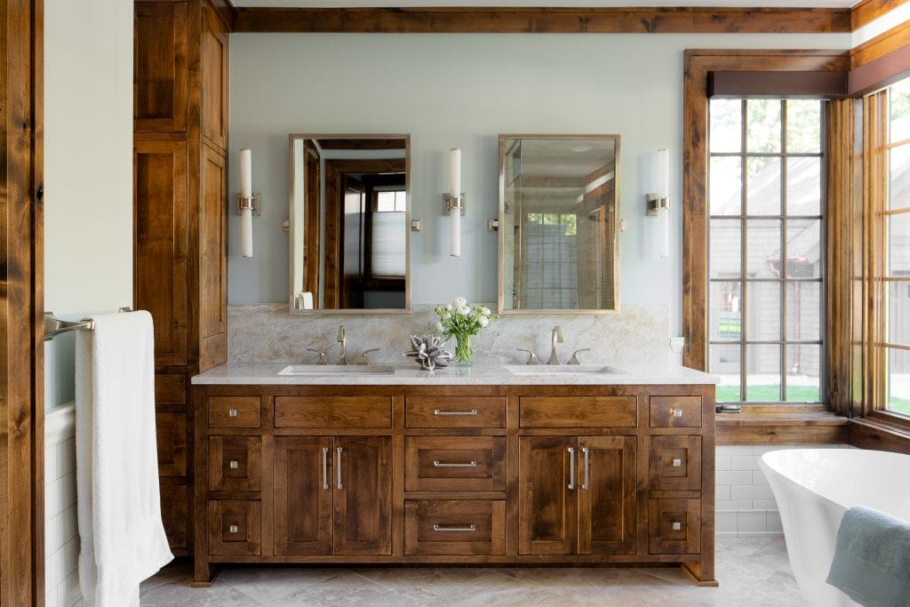 LAKE POLASKI 7 Bathroom with dual sinks and wood cabinetry near large window.