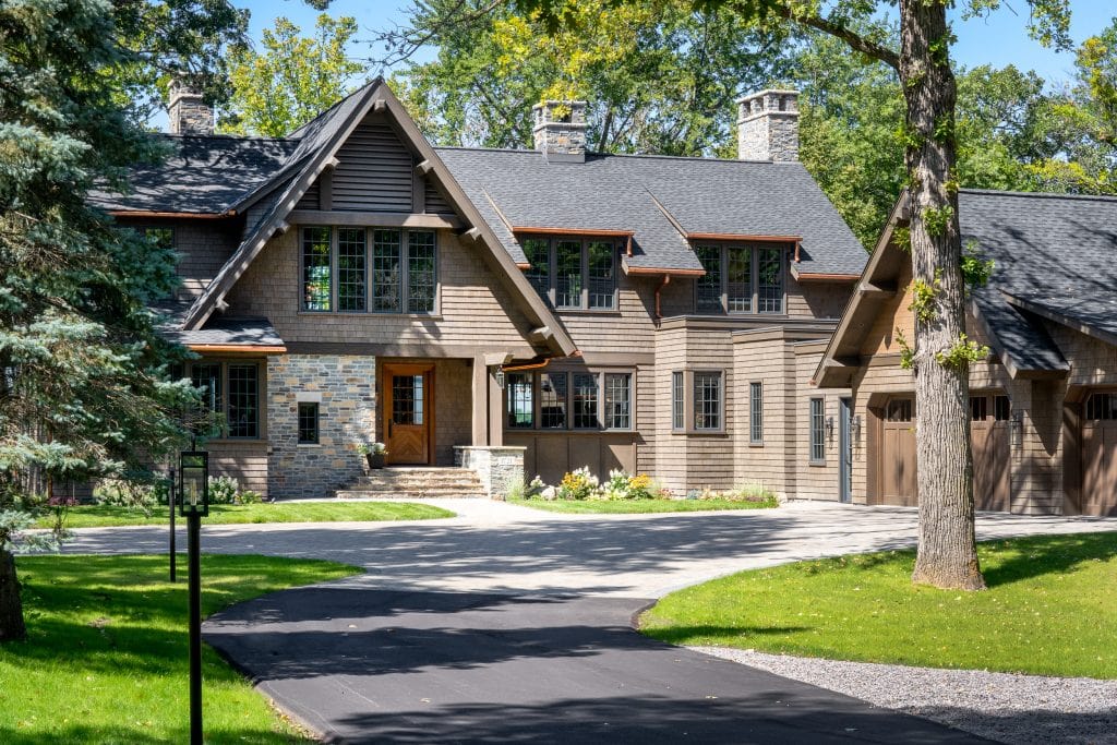LAKE POLASKI 2 Craftsman-style home with stone and cedar exterior near wooded drive.